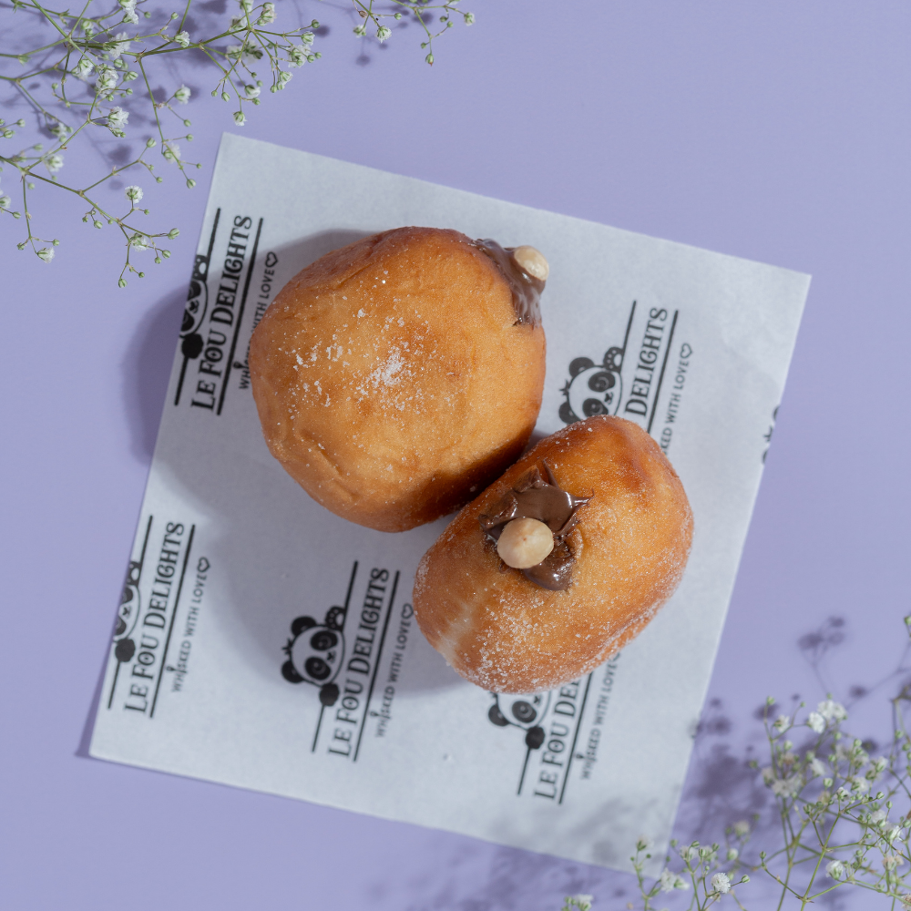 Soft Italian Bomboloni generously filled with creamy Nutella and dusted with fine sugar & handcrafted fresh daily by Le Fou Delight, Vadodara. Order now.