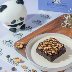 Slice of rich chocolate walnut brownie showing crackly crust and crunchy nuts
