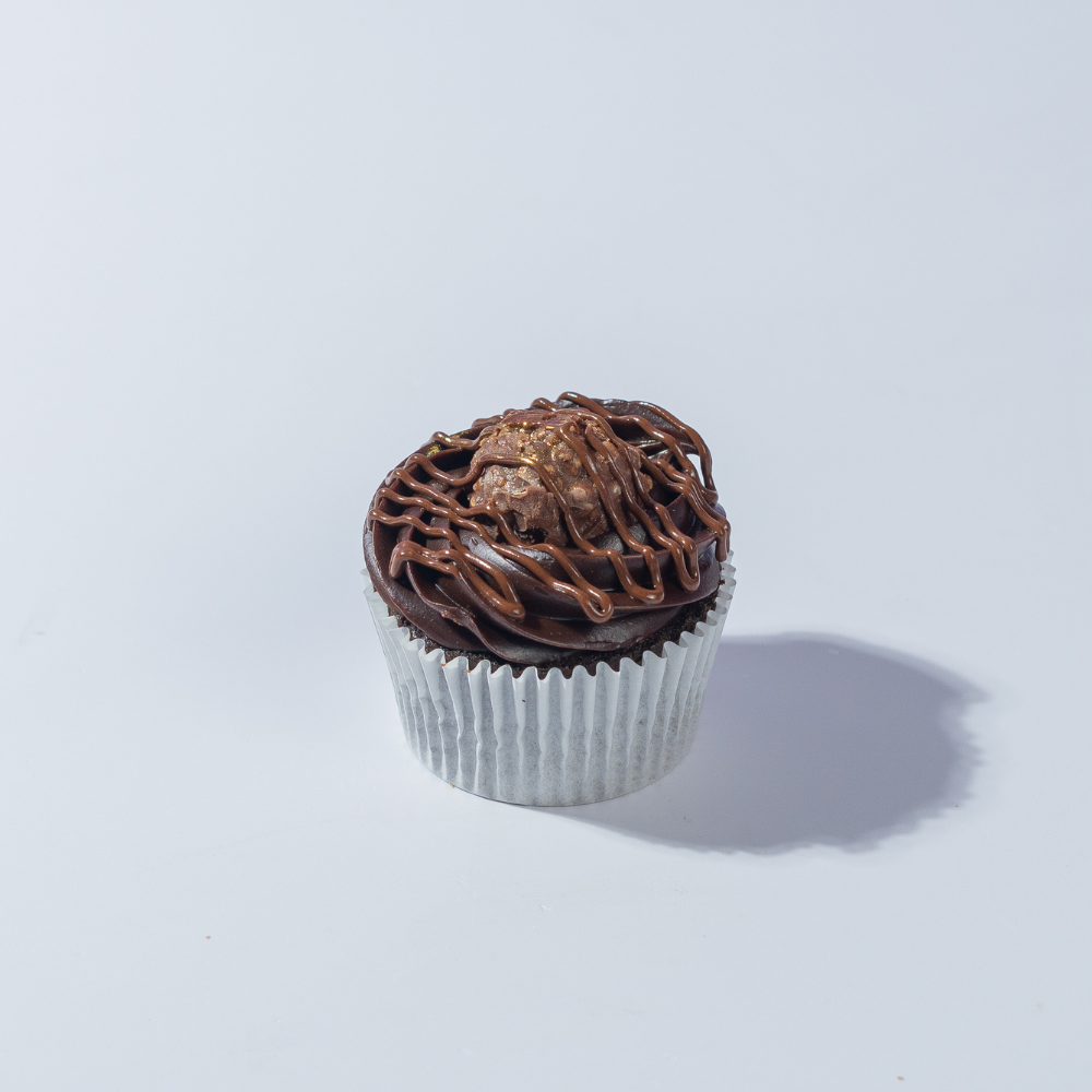 Ferrero Rocher Cupcake (3) Ferrero Rocher Cupcake in Vadodara topped with chocolate frosting, Nutella filling, and Ferrero Rocher by Le Fou Delight