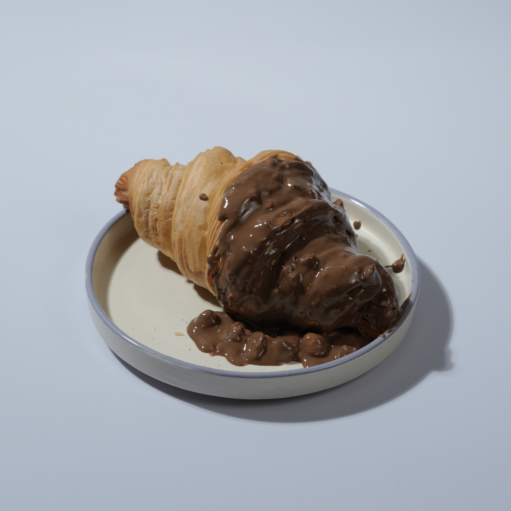 Rocher Glazed Croissant in Vadodara filled with Nutella and topped with Ferrero Rocher-inspired glaze by Le Fou Delight