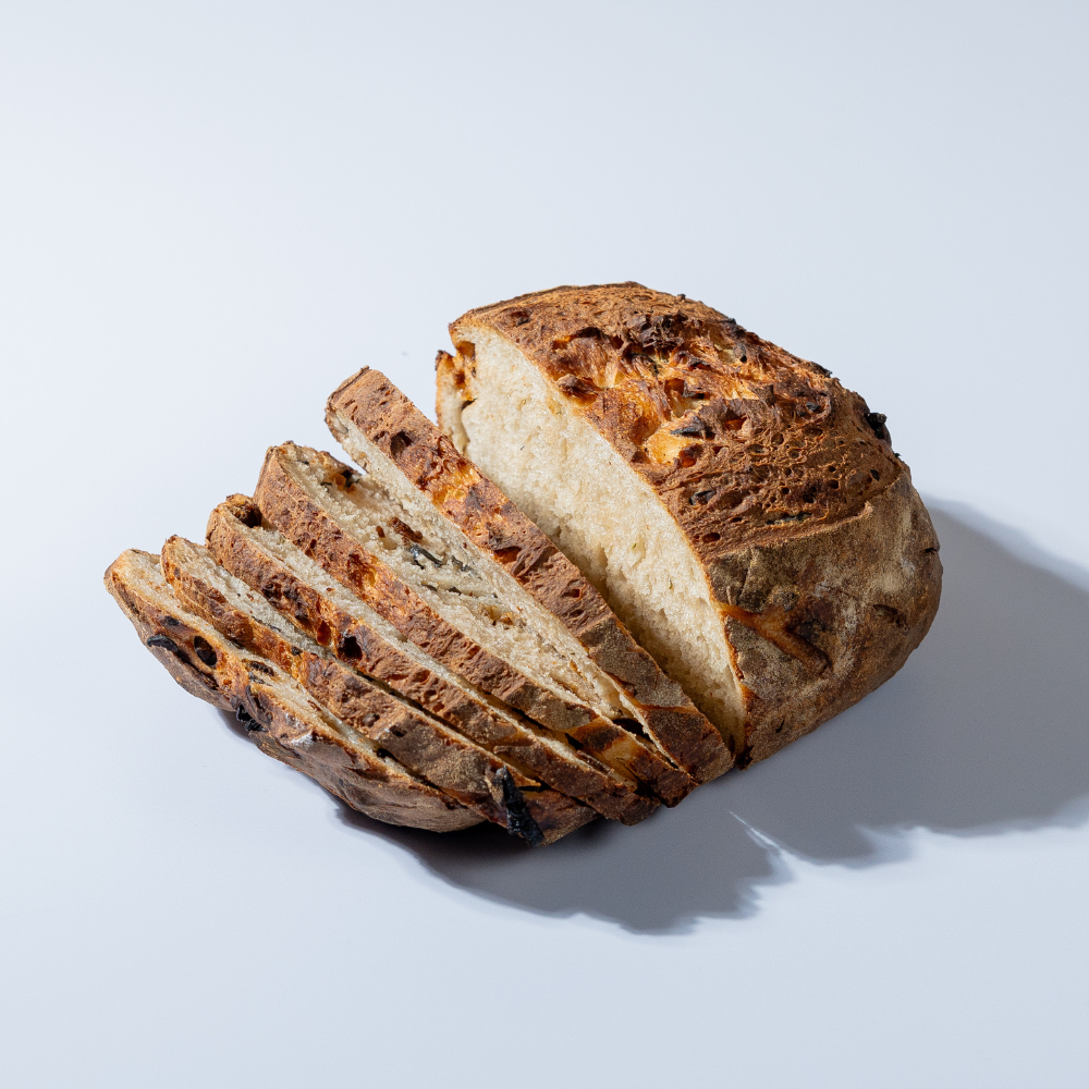 Freshly prepared savory olive and sun-dried tomato sourdough bread ready for delivery in Vadodara