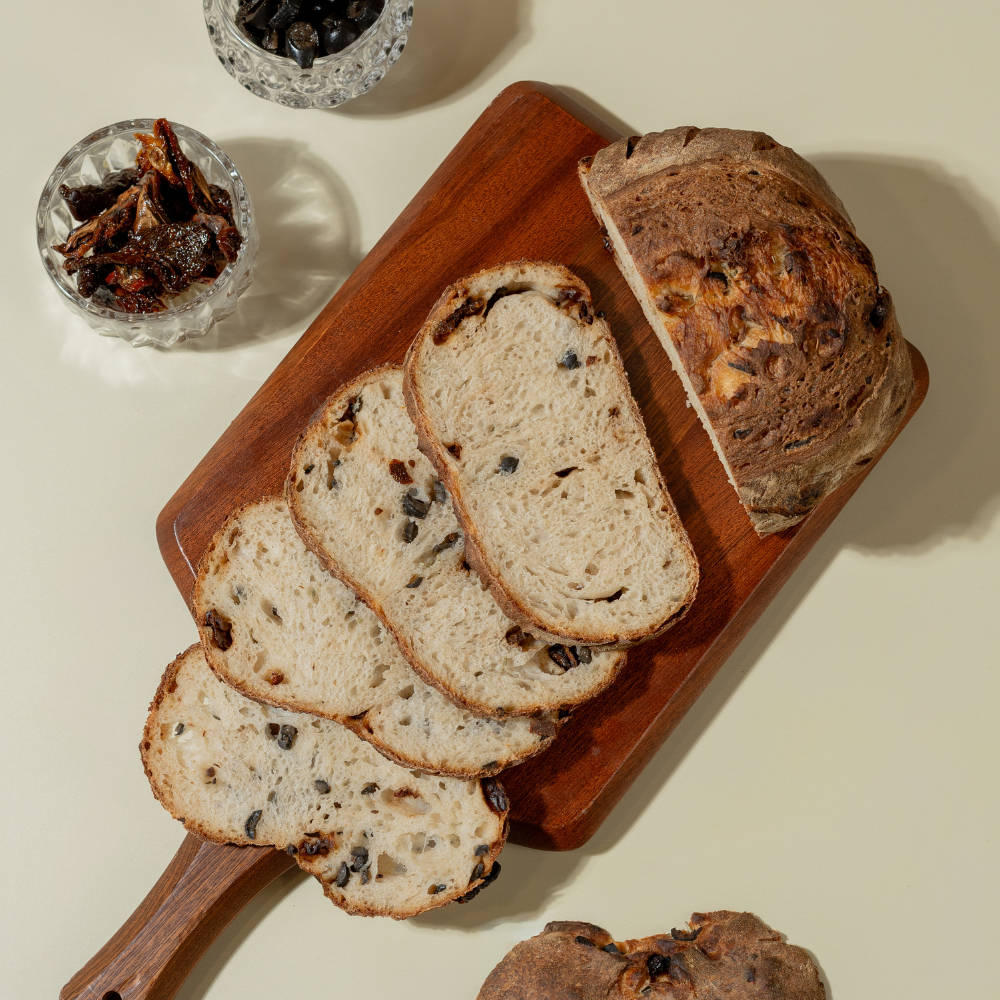 Freshly prepared savory olive and sun-dried tomato sourdough bread ready for delivery in Vadodara