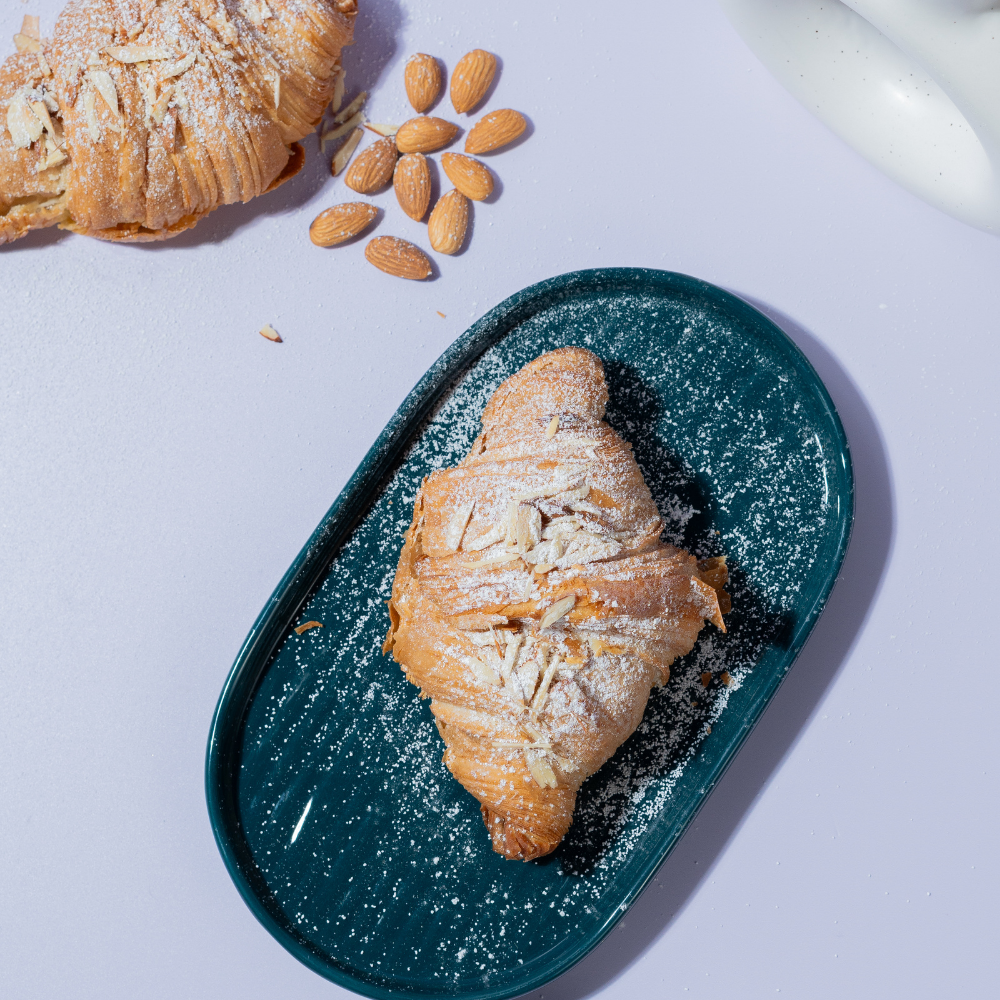 Golden toasted almond croissant sliced open to reveal smooth frangipane filling