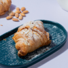 Golden toasted almond croissant sliced open to reveal smooth frangipane filling