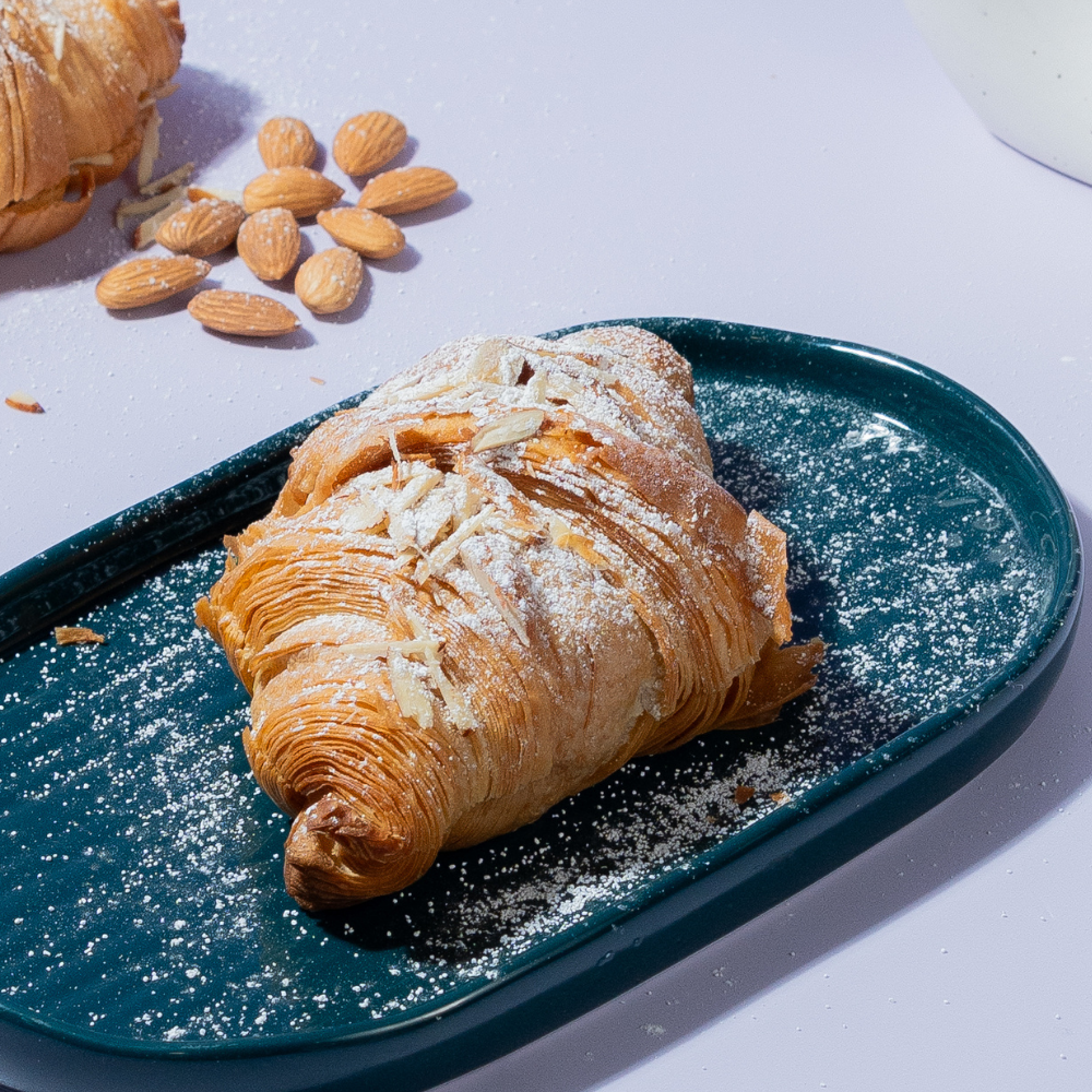 Golden toasted almond croissant sliced open to reveal smooth frangipane filling