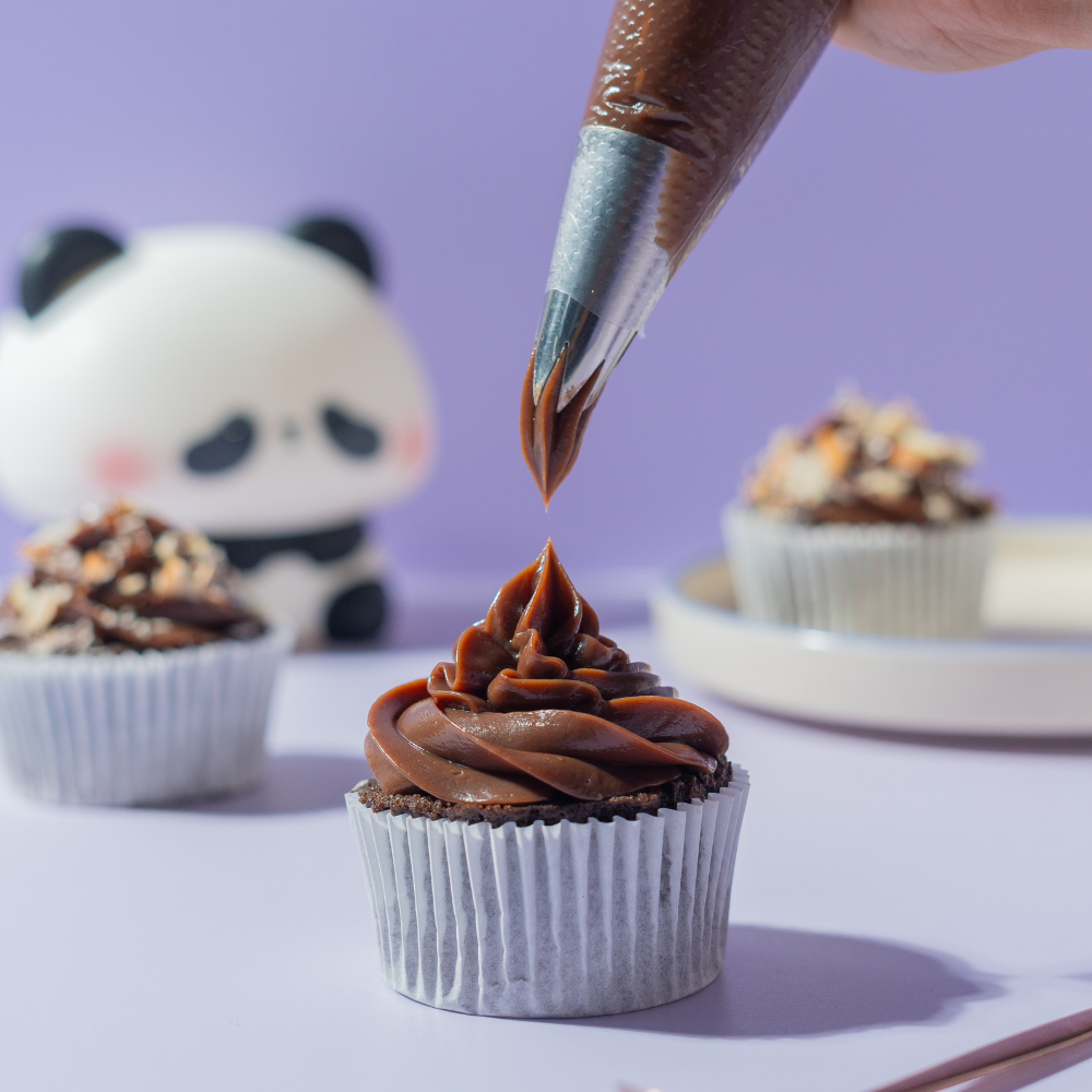 Almond Milk Chocolate Cupcake (3) Almond Milk Chocolate Cupcake in Vadodara topped with milk chocolate ganache, roasted almonds, and filled with almond praline by Le Fou Delight