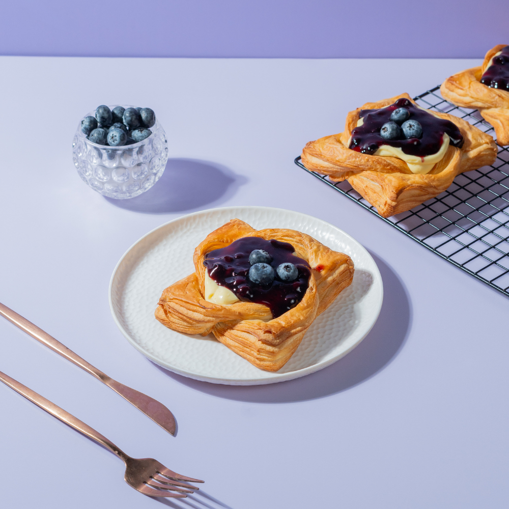 Golden baked blueberry custard Danish pastry topped with fresh blueberry filling