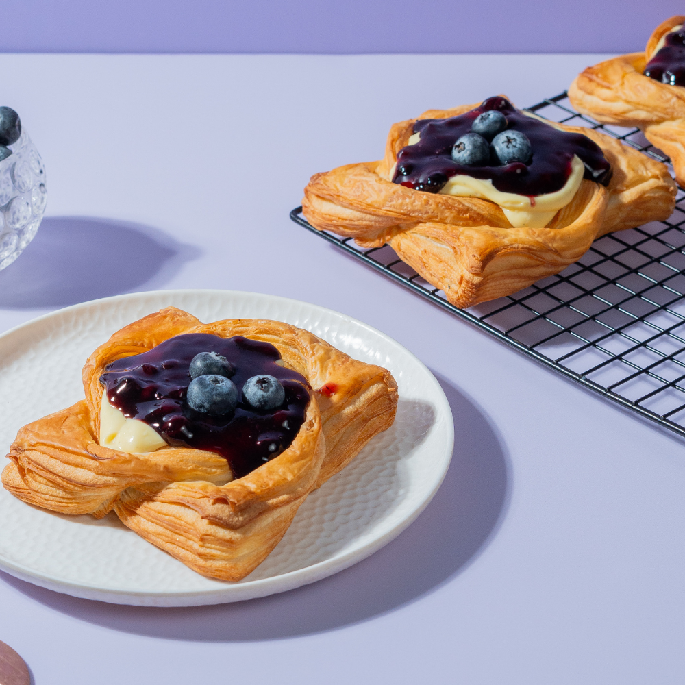 Golden baked blueberry custard Danish pastry topped with fresh blueberry filling