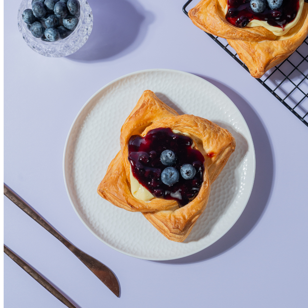 Golden baked blueberry custard Danish pastry topped with fresh blueberry filling