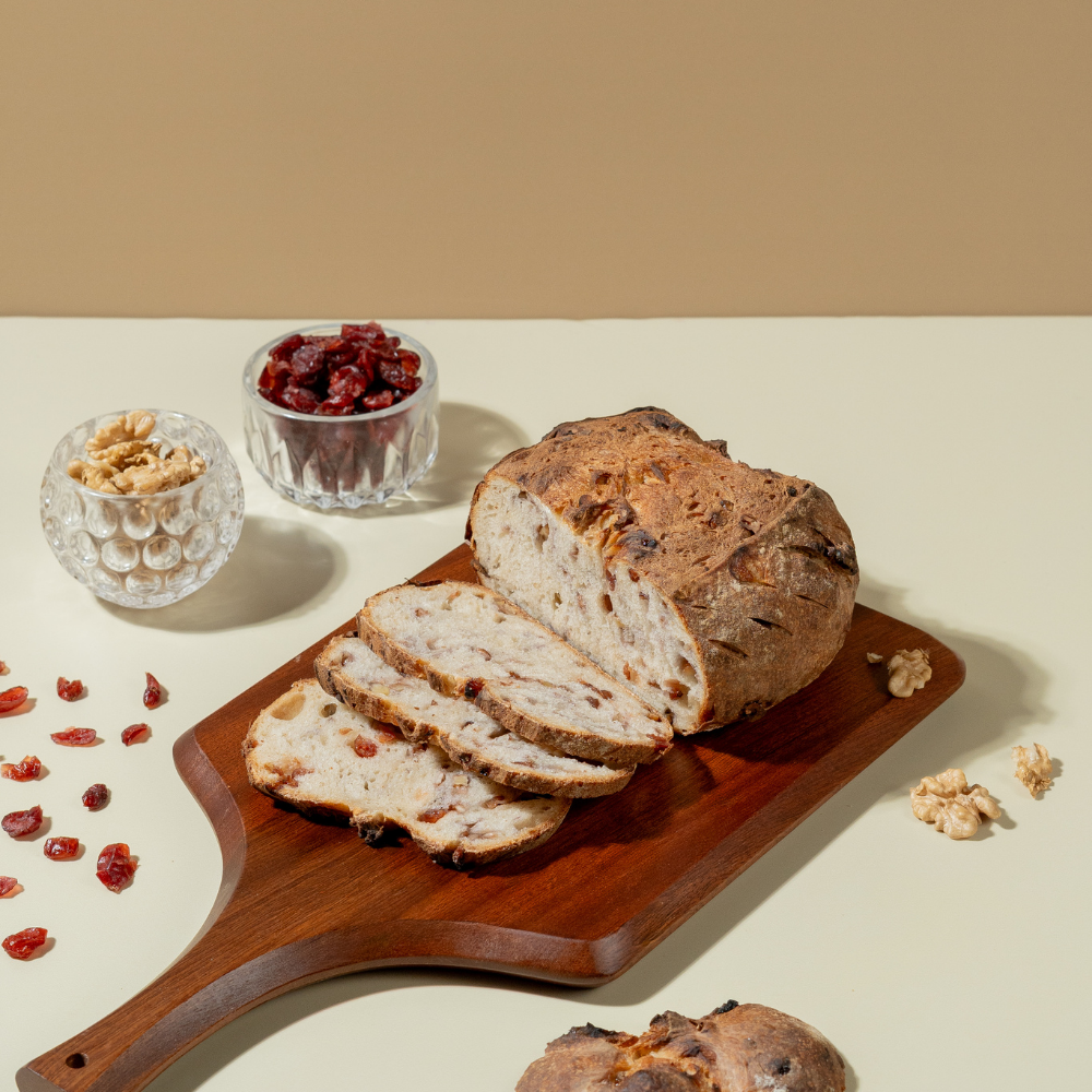Freshly baked artisan cranberry and walnut sourdough bread loaf with crisp golden crust by Le Fou Delight Vadodara