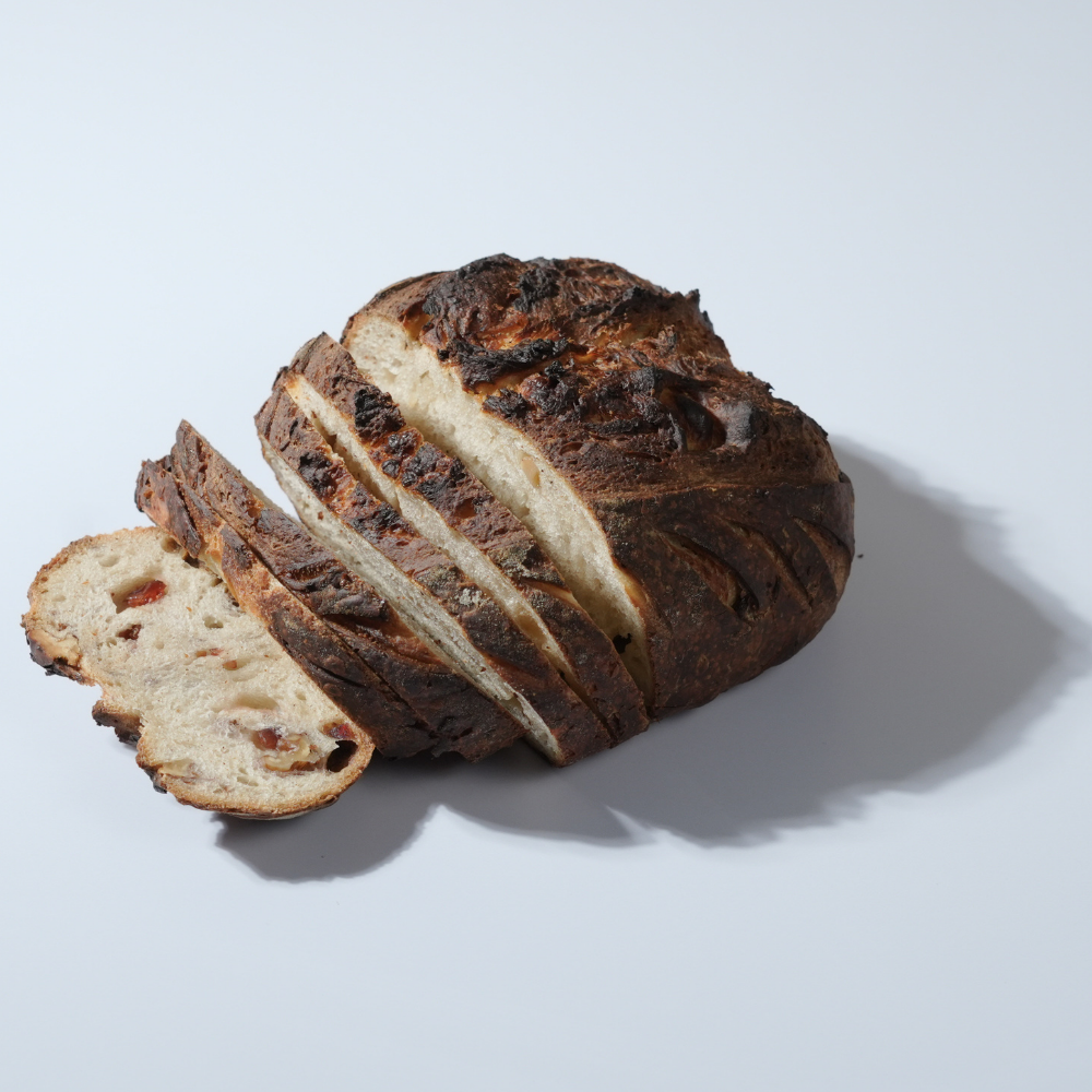 Freshly baked artisan cranberry and walnut sourdough bread loaf with crisp golden crust by Le Fou Delight Vadodara