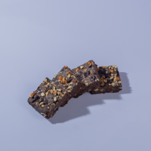 Fudgy gluten-free ragi chocolate brownie slice topped with healthy seeds