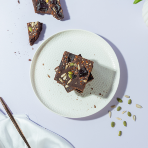 Fudgy gluten-free ragi chocolate brownie slice topped with healthy seeds
