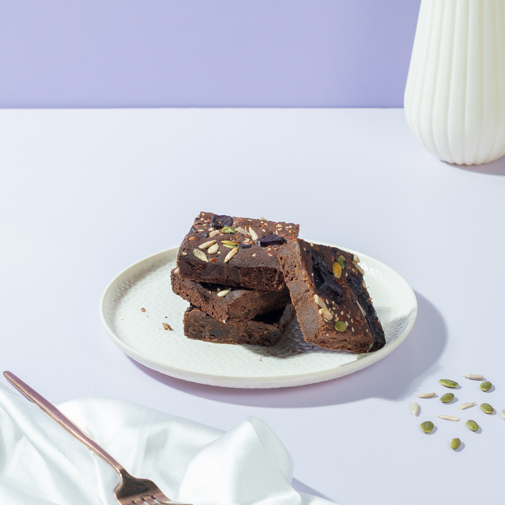 Fudgy gluten-free ragi chocolate brownie slice topped with healthy seeds