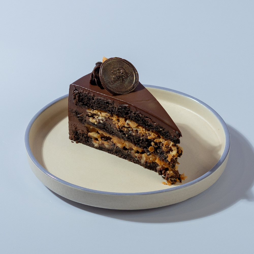 Le Fou’s Crazy Cake Slice with chocolate layers and crunchy nuts