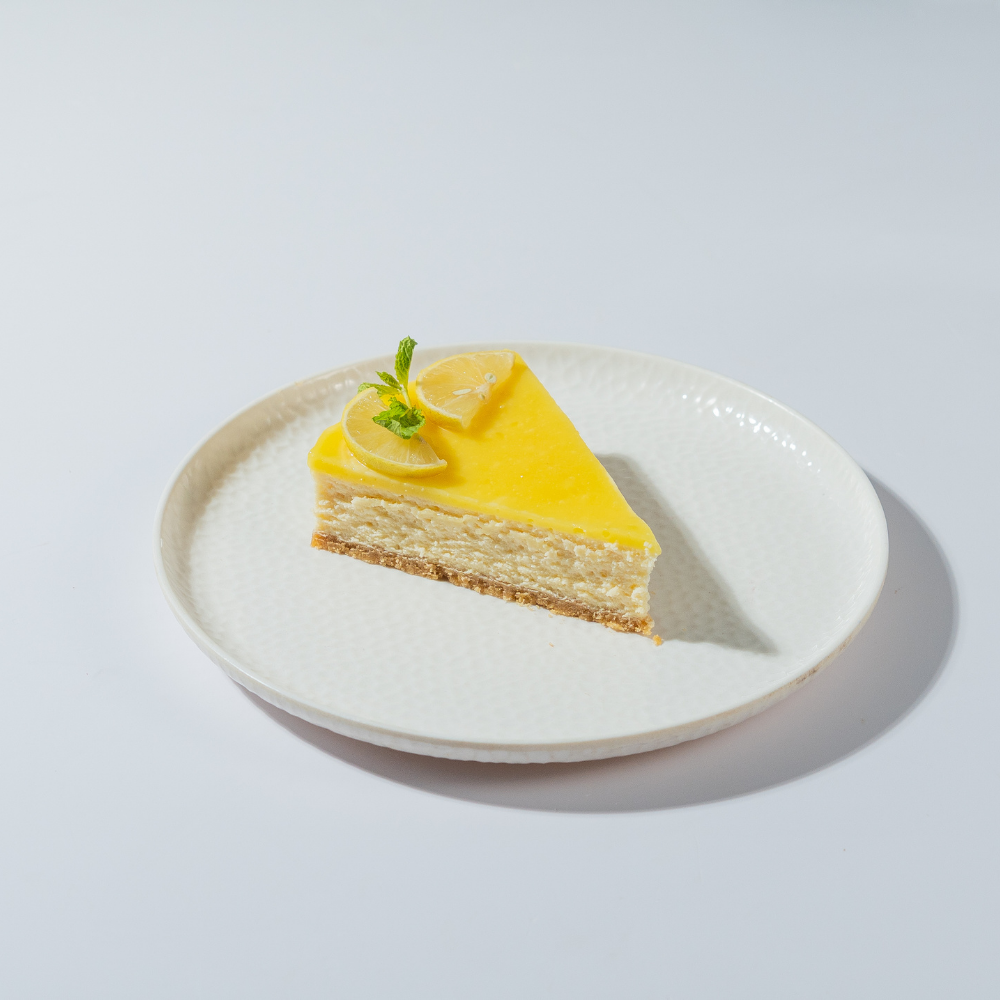 Fresh Lemon Cheesecake in Vadodara by Le Fou Delight with creamy New York-style filling, buttery biscuit crust, and fresh lemon topping.