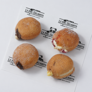 Pack of 4 Bomboloni in Vadodara by Le Fou Delights with chocolate, vanilla, and fruity fillings, freshly prepared and dusted with sugar.