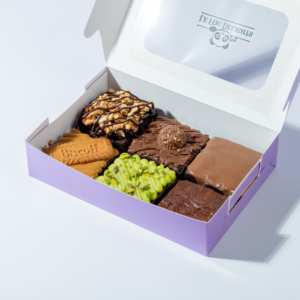 Box of 6 brownies in Vadodara by Le Fou Delight featuring assorted fudgy brownies with chocolate, pistachio, caramel, and nut toppings.