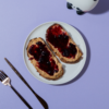 Toasted artisan sourdough slice loaded with peanut butter and rich berry fruit jam