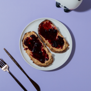 Toasted artisan sourdough slice loaded with peanut butter and rich berry fruit jam