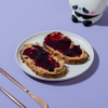 Toasted artisan sourdough slice loaded with peanut butter and rich berry fruit jam