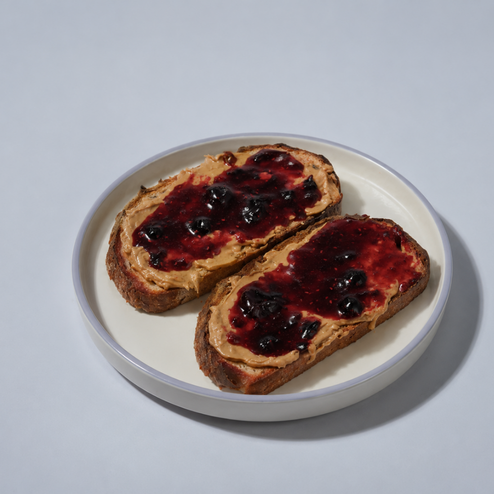 Toasted artisan sourdough slice loaded with peanut butter and rich berry fruit jam