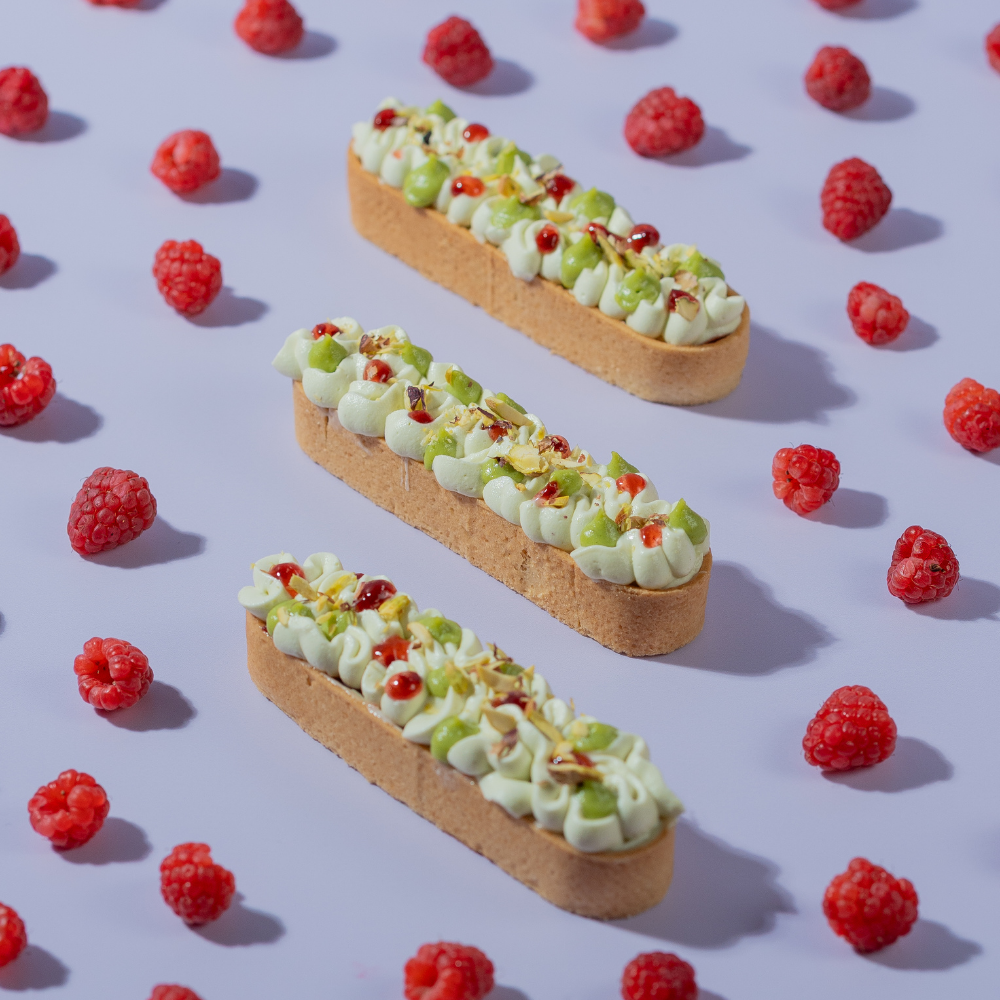 Raspberry Pistachio Tart slice with visible raspberry compote, Le Fou Delight