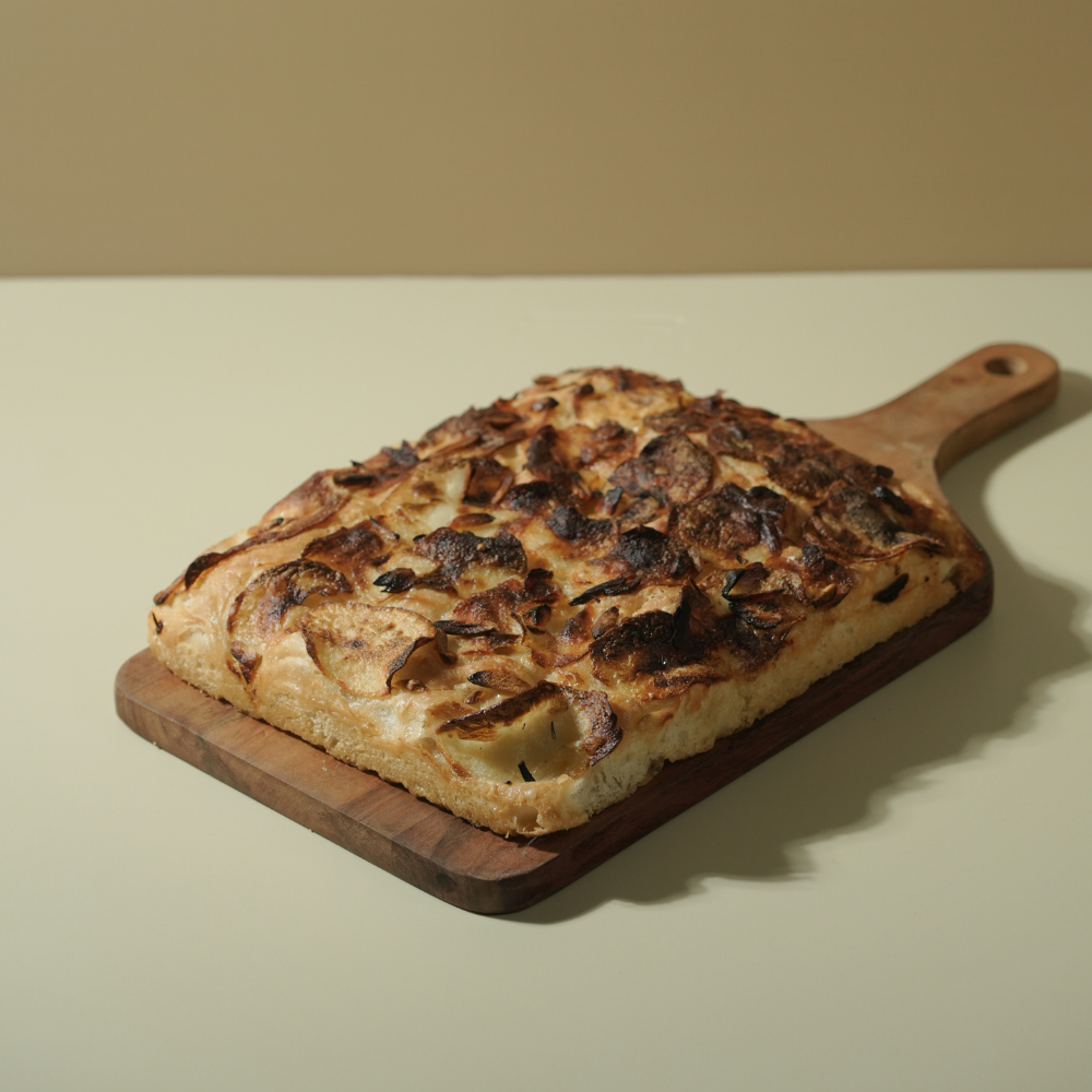 Freshly baked Italian roasted garlic potato focaccia bread drizzled with olive oil by Le Fou Delight Vadodara